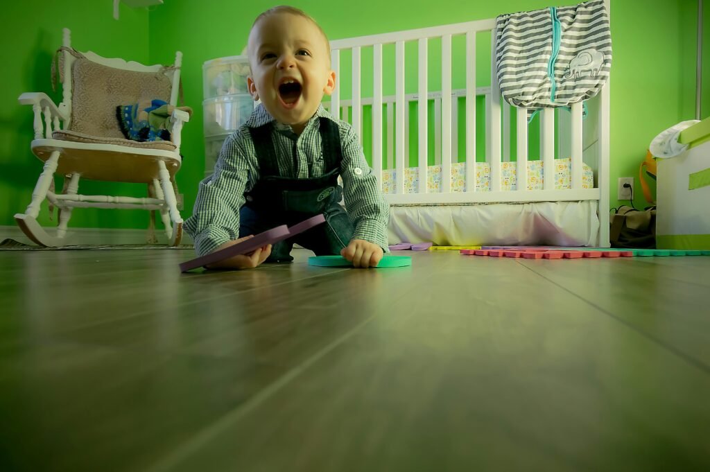 pexels-photo-315265-315265 Delightful baby boy crawling on a wooden floor, playing happily in a vibrant green nursery.