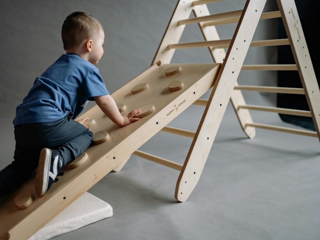 pexels-photo-8430599-8430599 A young boy enjoys playtime on a wooden indoor climbing set, combining fun and exercise.